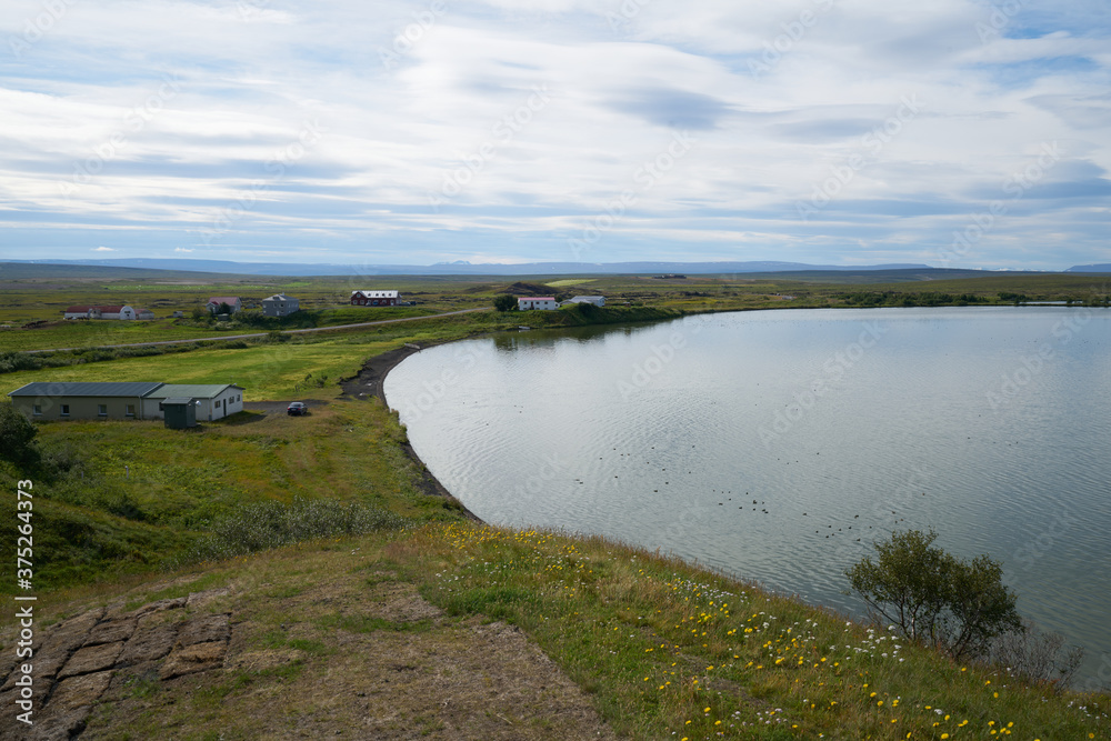 A sunny day on lake Myvatn, Iceland. Clouds reflected in the blue water of a volcanic lake.