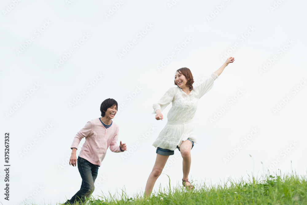丘を走るカップル