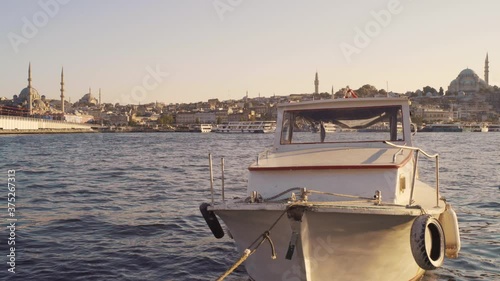 The boat in the Golden Horn Bay, seagulls circle over the Rustem Pasha Mosque.