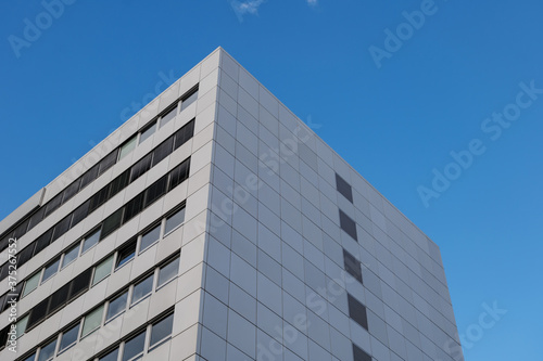 Close up detail at corner of white cladding facade with rectangular windows and reflected glass of modern office building. Abstract Typical Architectural Geometry elements background.