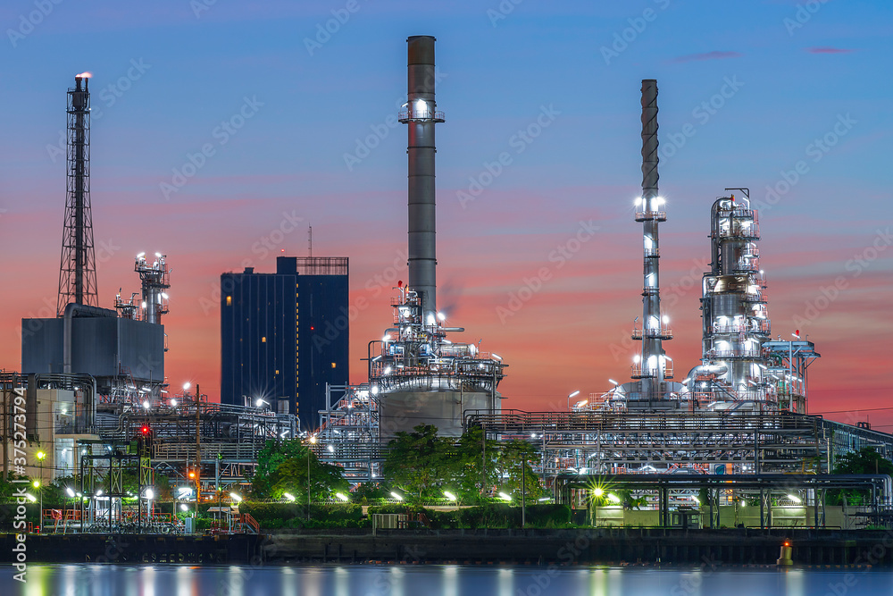 Oil refinery reflected along with river during twilight Oil refinery reflected along with river during twilight