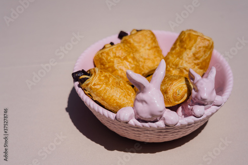 Close up of pink kitchenware with bunnies and rolles with chocolate photo