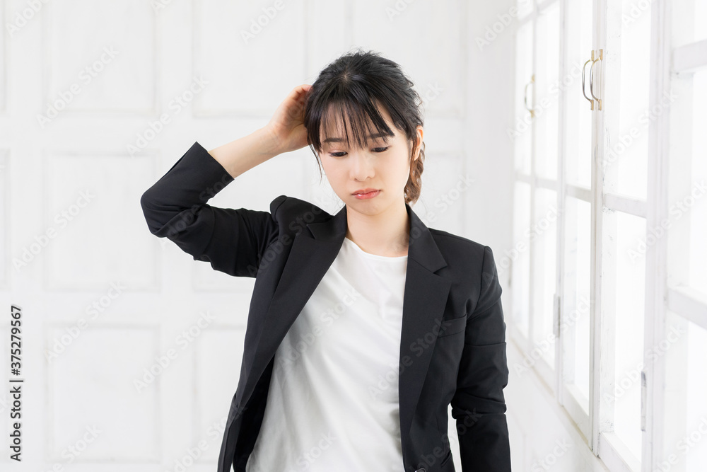 頭を抱える若いビジネスウーマン 頭を抱える若いビジネスウーマン