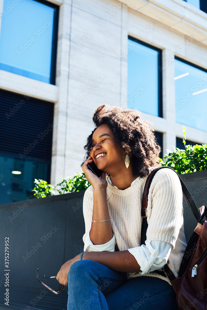 Fototapeta premium young pretty african girl posing cheerful on city background, lifestyle outdoor people concept