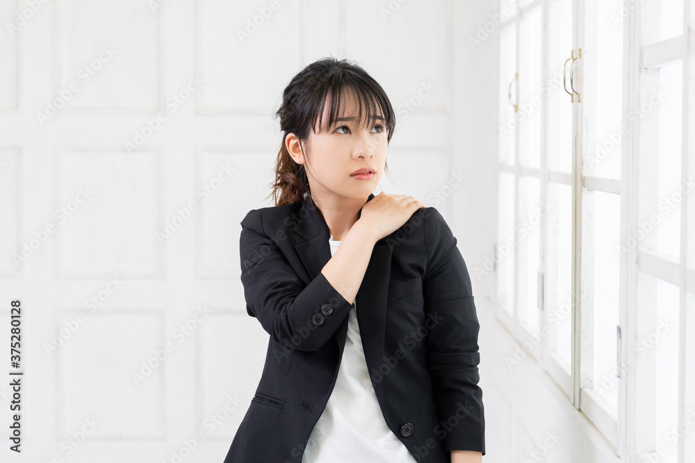 肩に手を当てる若いビジネスウーマン 肩に手を当てる若いビジネスウーマン