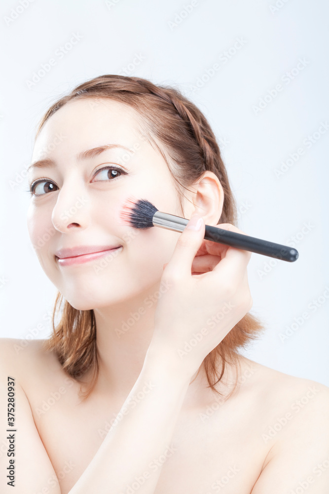 チークを塗る女性 チークを塗る女性