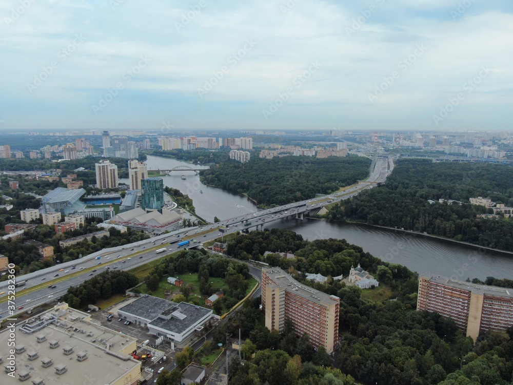 Aerial view car traffic on the bridge over the river expressway in the big city. Beautiful landscape of the city from the drone
