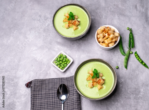 Healthy Green pea soup with croutons top view.