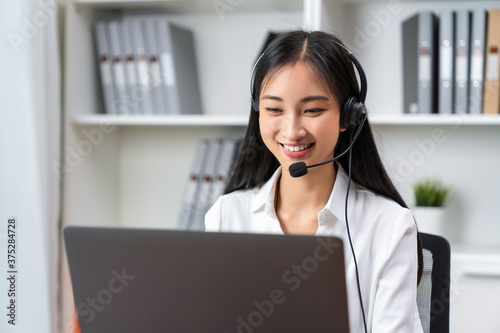 Asian business woman wear headset and working on telemarketing with online customer support.