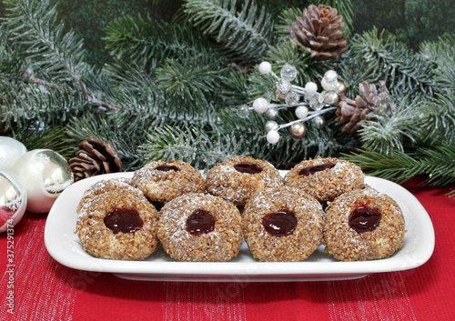 Pecan thumbprint cookies with raspberry jam in a Christmas setting. Macro