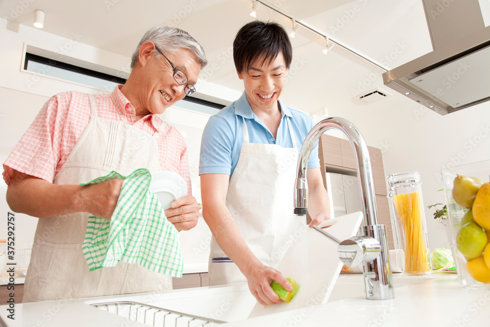 Obraz premium 食事の後片付けをする親子