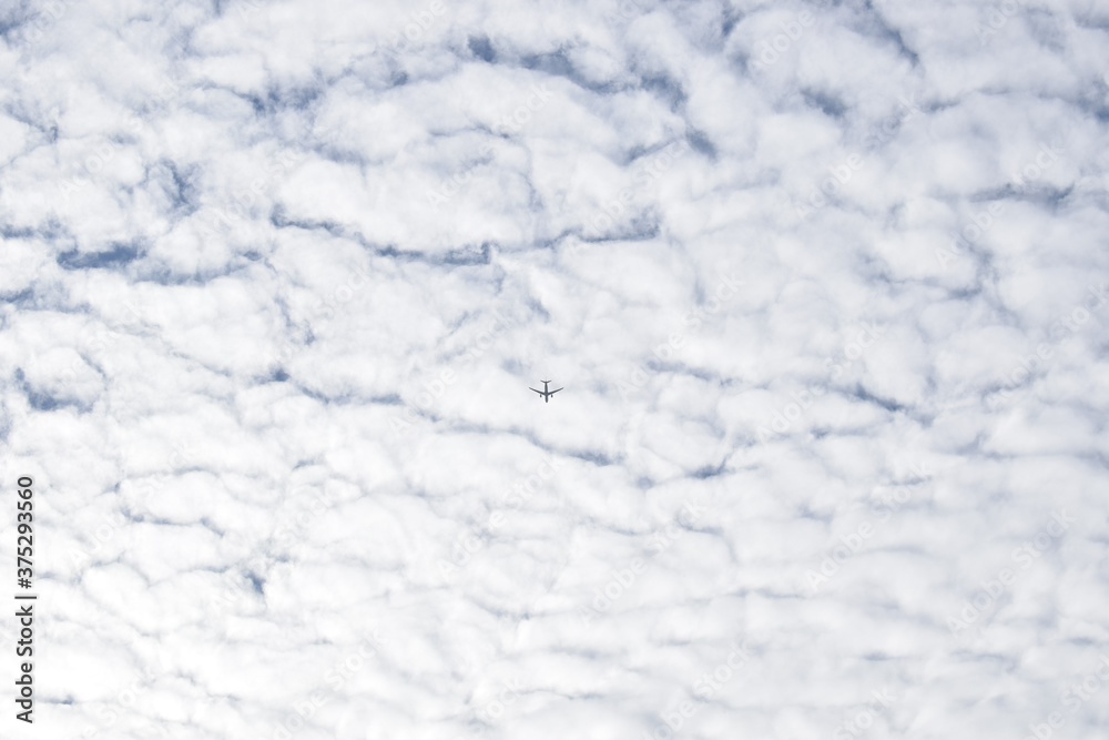 Airplane, white clouds and the blue sky. Fluffy nature 