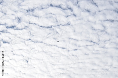 Airplane, white clouds and the blue sky. Fluffy nature 