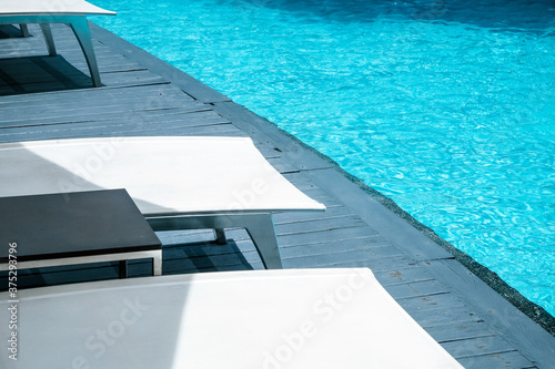 Many white chaise lounge by the pool