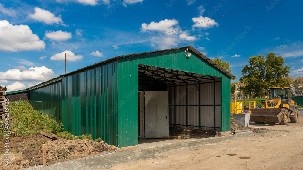 A large metal industrial warehouse for storing goods for storing goods. Industrial concept of transportation, loading and storage of goods A large metal industrial warehouse for storing goods for storing goods. Industrial concept of transportation, loading and storage of goods
