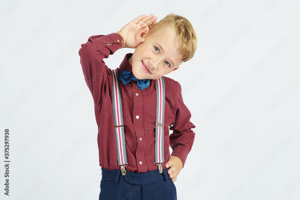 A portrait of a schoolboy who pretends to hear poorly. Isolated background. A portrait of a schoolboy who pretends to hear poorly. Isolated background.