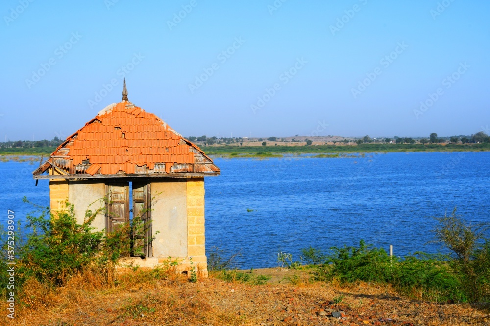 Hut on banks of the river of India, old hut, Little old house on banks of the river at sunset in silence Hut on banks of the river of India, old hut, Little old house on banks of the river at sunset in silence