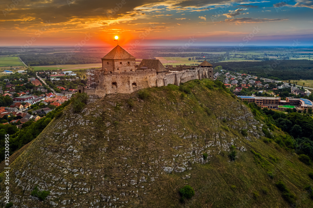Sumeg, Hungary - Aerial view of the famous High Castle of Sumeg in Veszprem county at sunset with colorful clouds and dramatic colors of sunset at background on a summer afternoon