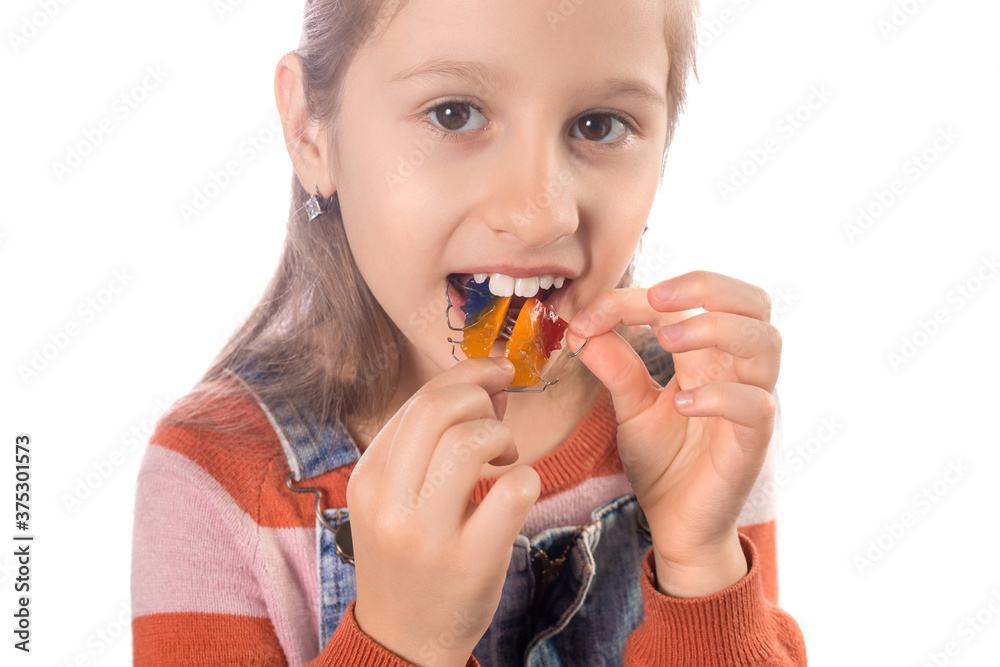 Little girl with orthodontics appliance isolated on white background. Little girl with orthodontics appliance isolated on white background.