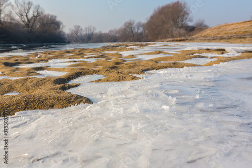 Winter scenery with a wild river, surrounded by frost and fresh snow © Calin Tatu