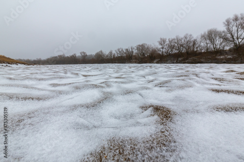 Hoarfrost and fresh powder snow in winter, on a wild, beautiful, river bank photo