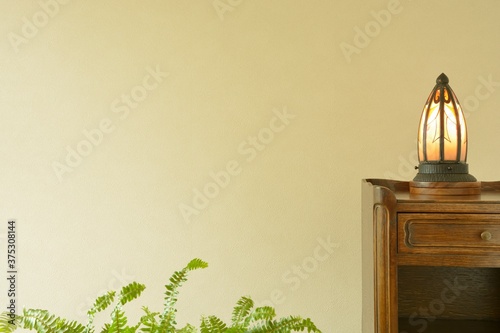 put a antique art deco lamp on a oak side table.This expensive furniture is made in England.  blurred background with copy space. photo