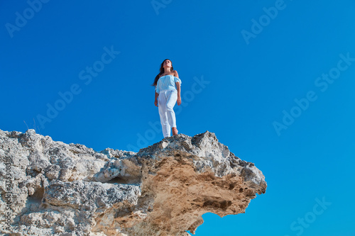 Lady looking up standing on high mountain. Relaxation or Modeling on Virgin nature. Woman posing on fresh air