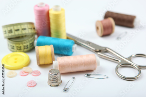 different sewing accessories on the table. Threads, needles, pins, fabric and sewing scissors close up 