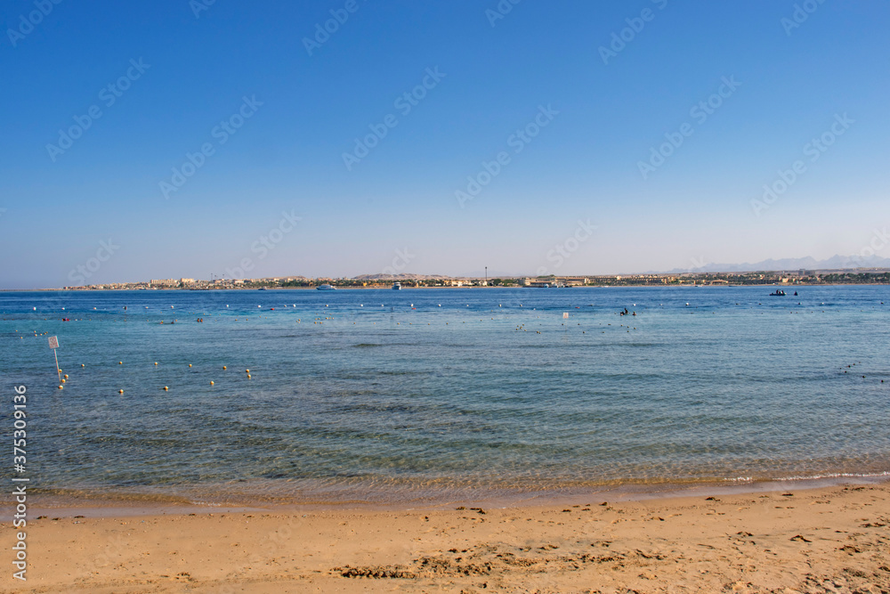 Tropical beach on a sunny day photo. Blue sea with a sandy beach.