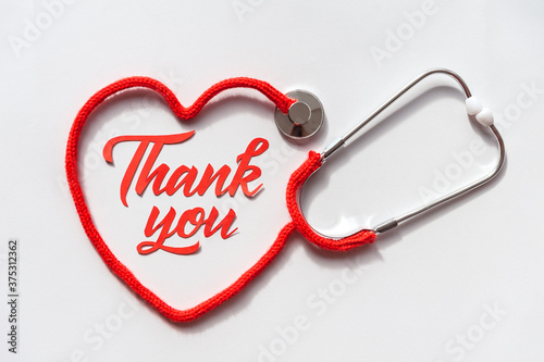 Stethoscope forming heart with its cord. Thank you doctor and Nurses and medical personnel team. Healthcare concept. Space for text. Soft focus. Top view.