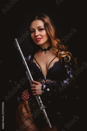 Flute player. Flutist with flute instrument. Pretty actress in stage costume with beautiful Golden hair and cleavage. Cute man with flute. Classic female musician isolated on black background