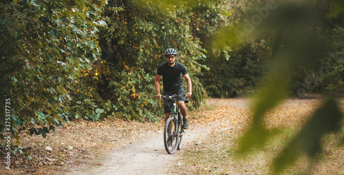 Bicycle training of an adult man in the forest outdoors. Healthy and active lifestyle. © Andrii Zastrozhnov