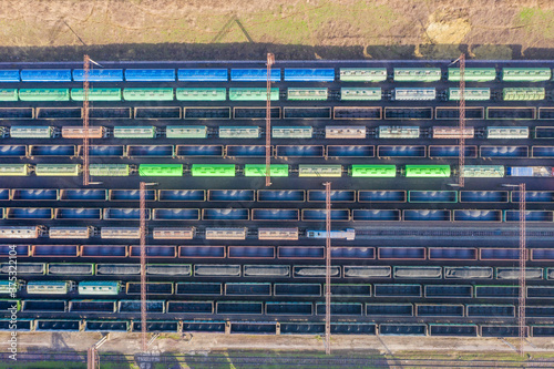 Railway station with freight wagons, hapras with unfilled cargo: coal, ore and grain. View from above.
