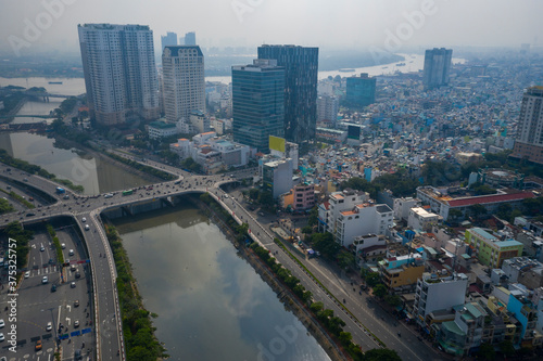 wide angle drone view of Ben Nghe canal featuring Saigon  Vietnam City skyline  Saigon river port  Calmette bridge and foggy morning day time traffic