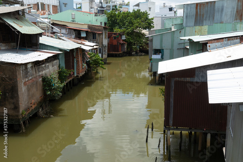 row of Houses made from corrugated iron and on stilts along a narrow canal in Ho Chi Minh City, Vietnam
