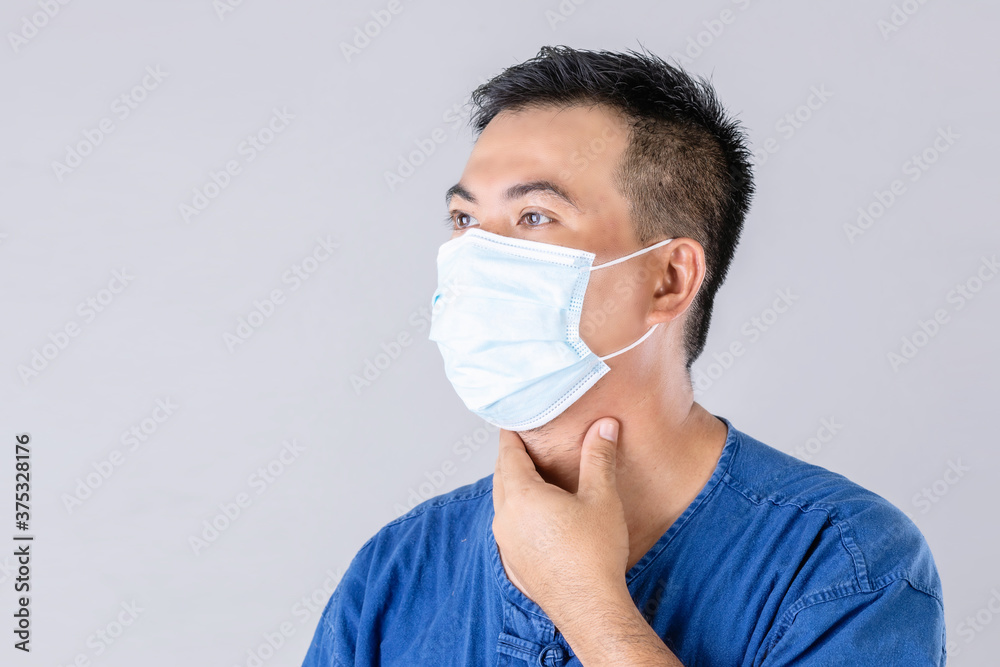 Thai farmer wearing protective face mask to prevent virus and touch on neck studio shot on grey background Thai farmer wearing protective face mask to prevent virus and touch on neck studio shot on grey background