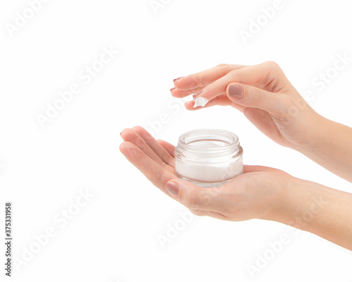 Young woman holding lotion and applying with fingers. Luxury cosmetic. Close-up front view copy space