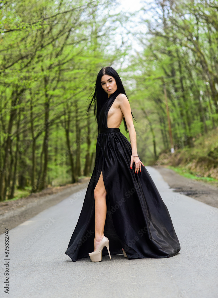 Sexy girl walk along road. Desire to wander. Stylish makeup and hair. Fashion model in elegant dress. Style from toe to head. Fashion look of sensual girl. Summer vacation. Elegance in every way