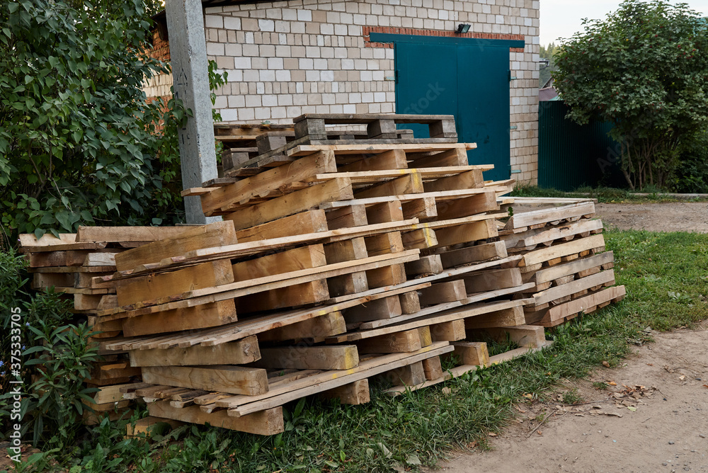 A stack of wooden pallets lying on the grass in the countryside. A stack of wooden pallets lying on the grass in the countryside.