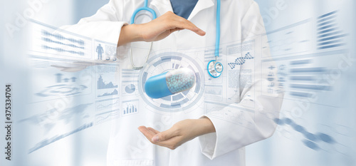 female doctor in white coat and stethoscope protects with the hands a capsule in a stats data background, pharmaceutical research and health cure safety.