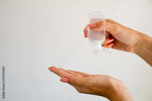 Hand sanitizer alcohol gel rub clean hands hygiene prevention of coronavirus virus outbreak. Woman hands using bottle of antibacterial sanitiser gel on the white background. bottle antibacterial gel