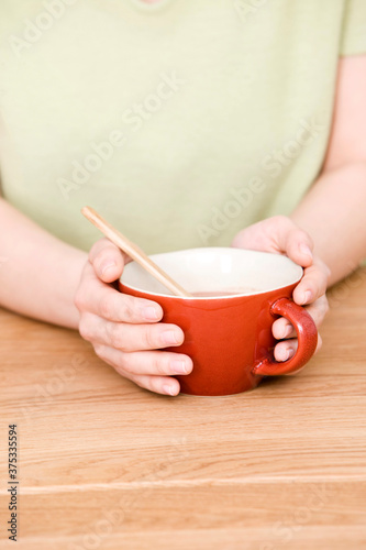 young woman's hands holding a cup