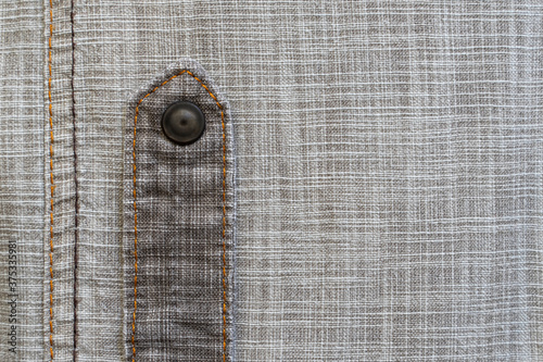Linen fabric texture. Close-up. A fragment of linen cloth. Rough fabric texture. Double machine stitching on fabric. Decorative elements of trousers. Loose threads. A series of photographs. Flat lay