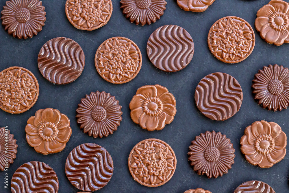 Milky and bitter round shape chocolate Madlen,designed on black background.The Sugar Feast or any festival celebration.Top view. Milky and bitter round shape chocolate Madlen,designed on black background.The Sugar Feast or any festival celebration.Top view.