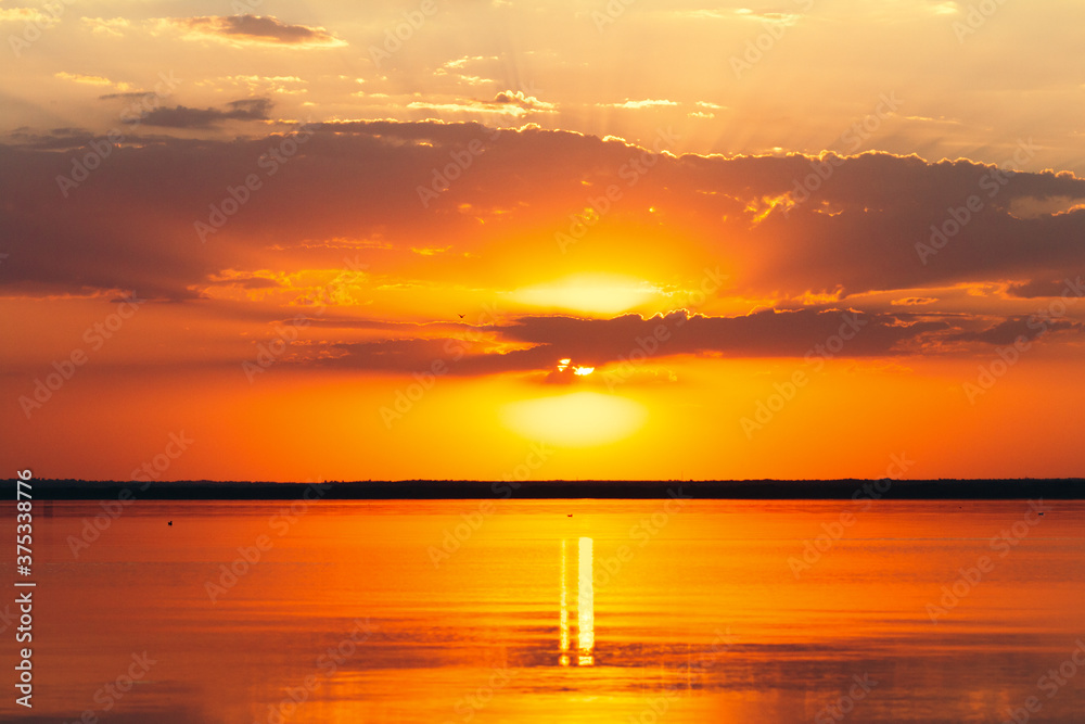 background of sunset on the sea, clouds lit by rays of sun, beautiful landscape, birds floating on water space