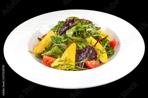Delicious salad with maize porridge, arugula and tomatoes on a plate