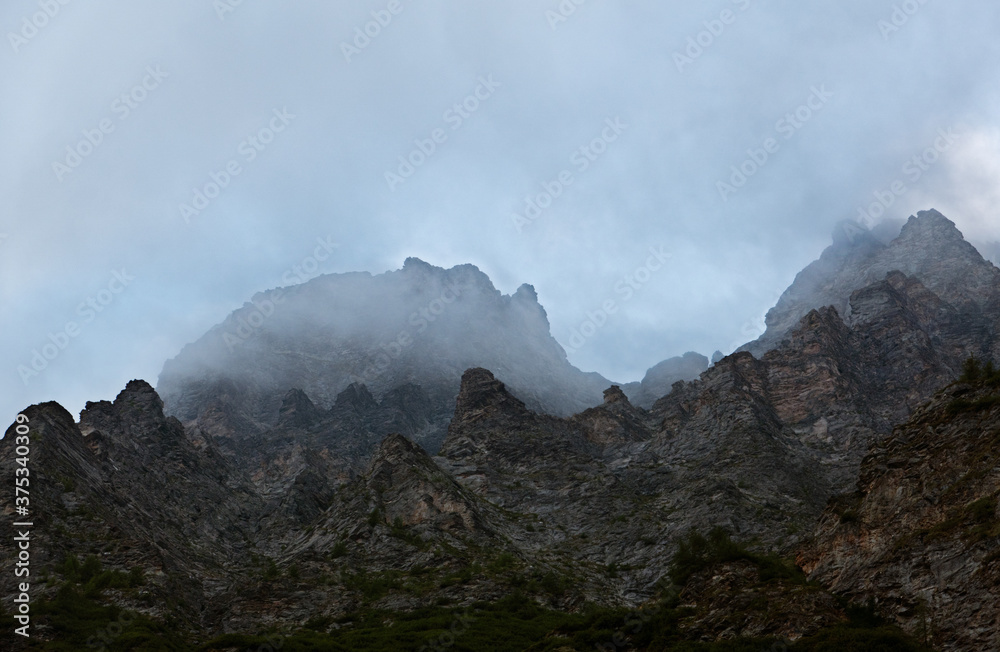 Creepy, steep rocks in a misty, scary landscape