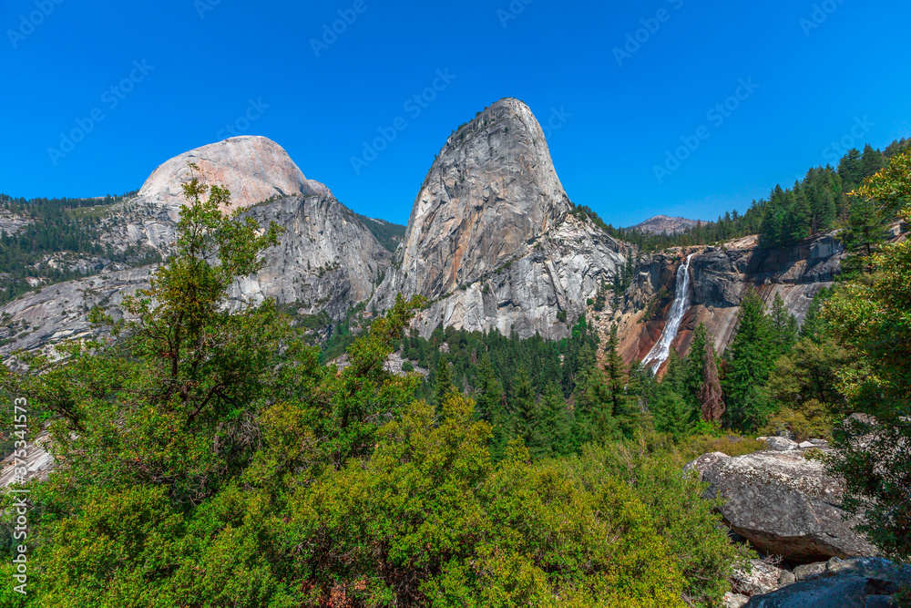 Panorama of Half Dome, Mt Broderick, and Liberty Cap with Nevada Fall waterfall on Merced River from Mist Trail in Yosemite National Park. Summer travel holidays in California, United States America.