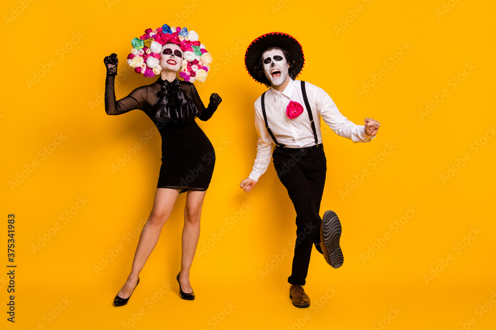 Full length body size view of his he her she nice glamorous spooky cheerful cheery ecstatic zombie couple dancing calavera having fun isolated bright vivid shine vibrant yellow color background Full length body size view of his he her she nice glamorous spooky cheerful cheery ecstatic zombie couple dancing calavera having fun isolated bright vivid shine vibrant yellow color background