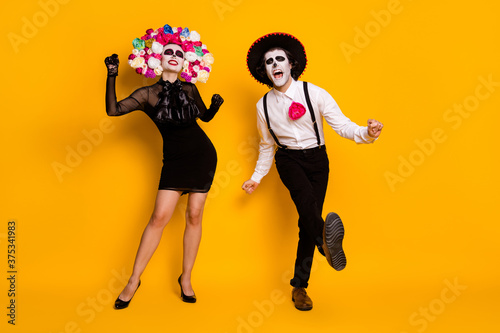 Full length body size view of his he her she nice glamorous spooky cheerful cheery ecstatic zombie couple dancing calavera having fun isolated bright vivid shine vibrant yellow color background